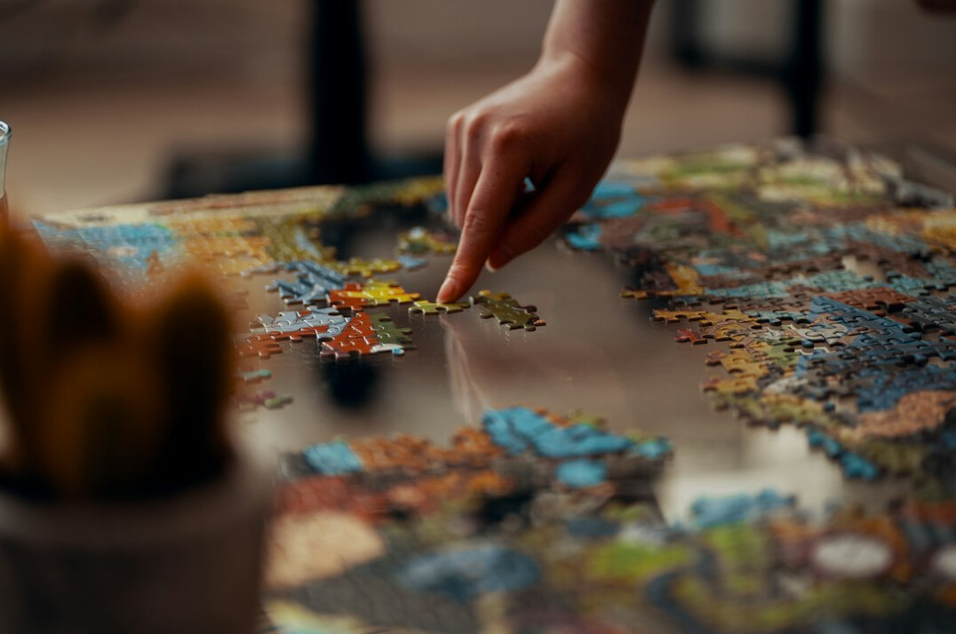 person solving jigsaw puzzle